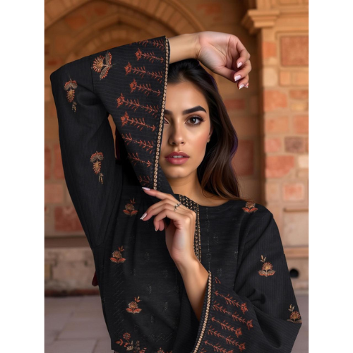 Woman wearing a black embroidered outfit with a brick wall background
