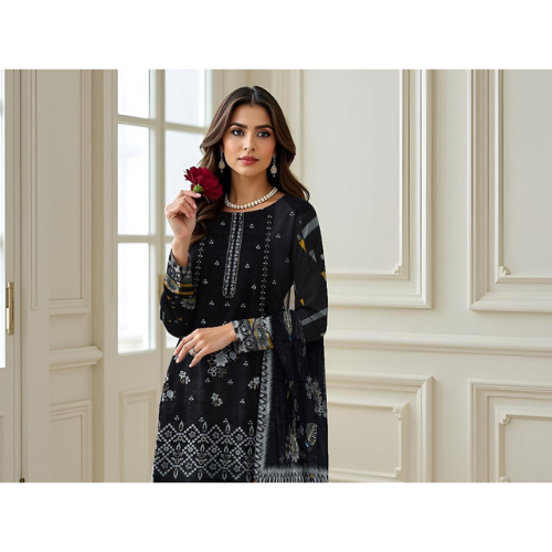 Woman in a black and white patterned outfit holding a red flower in an elegant interior setting.