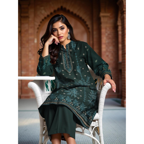 Woman in a dark green embroidered traditional outfit sitting on a white chair.