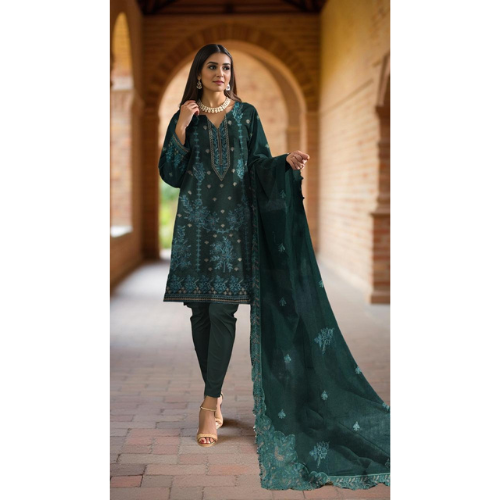 Woman wearing a dark green embroidered traditional outfit with a dupatta in an outdoor setting.