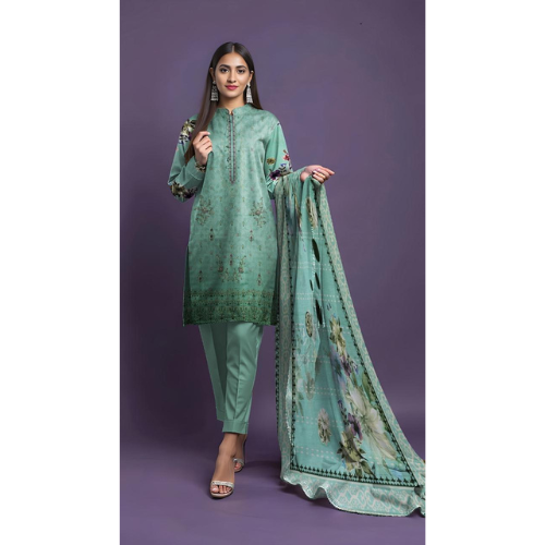 Woman wearing a green traditional outfit with a matching dupatta on a purple background