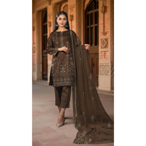 Woman wearing a brown embroidered outfit with a dupatta in front of an architectural background