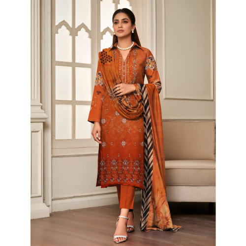 Woman wearing an orange embroidered traditional outfit with a matching dupatta in a decorative room.