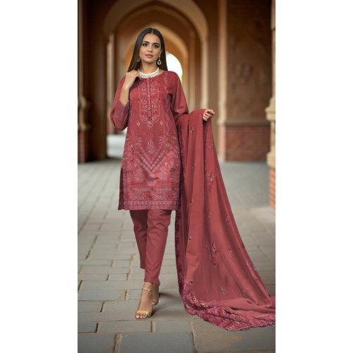 Woman in a maroon traditional outfit with embroidery standing in an archway.