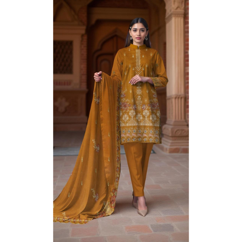Woman in a mustard yellow traditional outfit with a dupatta, standing in an architectural setting.