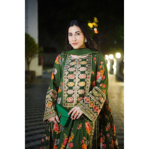 Woman wearing a green embroidered traditional outfit with a dark background